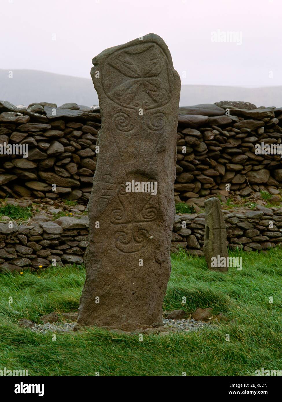 Two (of three) Early Christian cross-inscribed stones in an old walled monastic enclosure at Reask, Co Kerry, Republic of Ireland. The tall thin sands Stock Photo