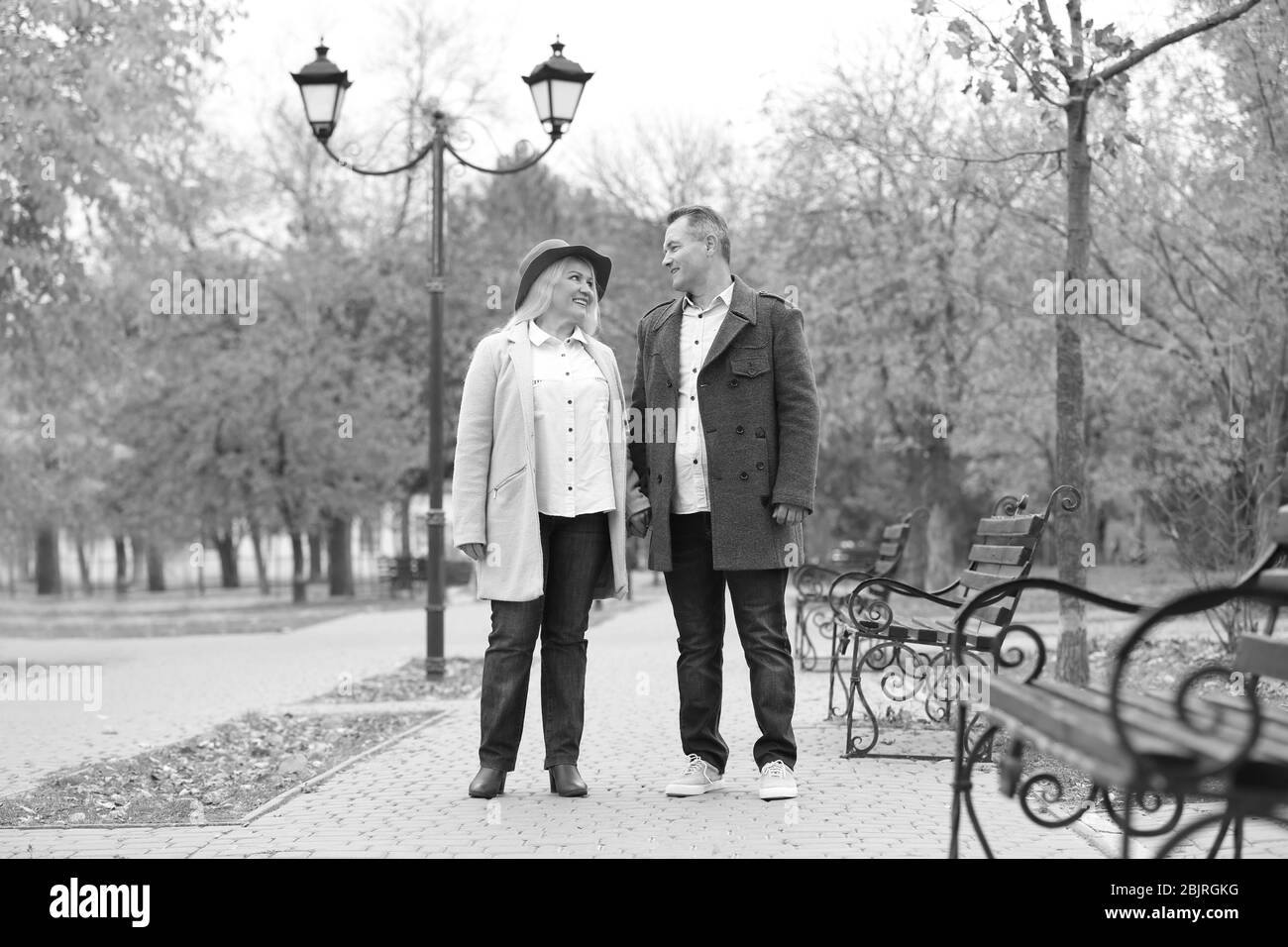 Mature couple walking in park, black and white effect Stock Photo - Alamy