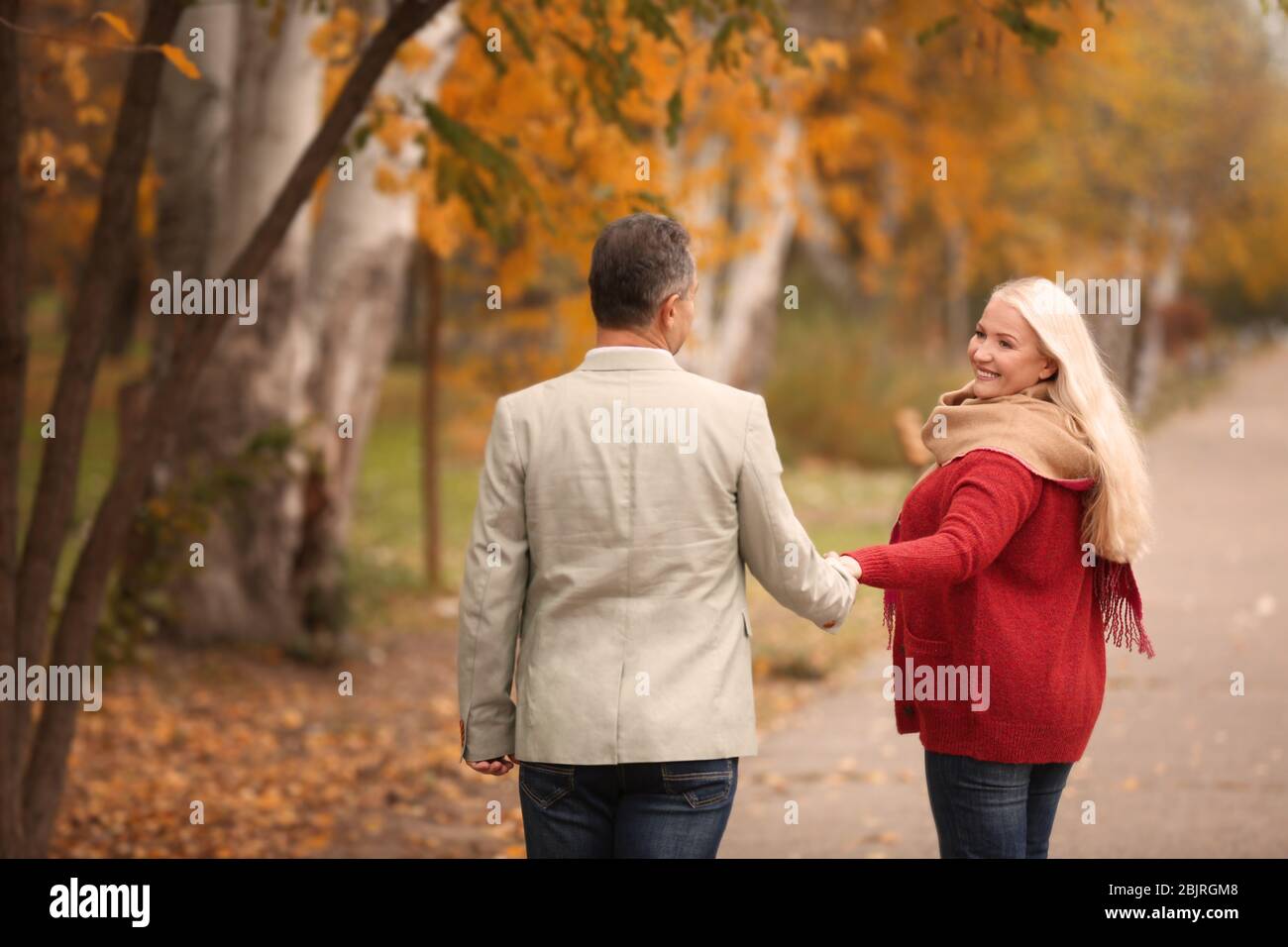 Mature couple walking in park on autumn day Stock Photo - Alamy