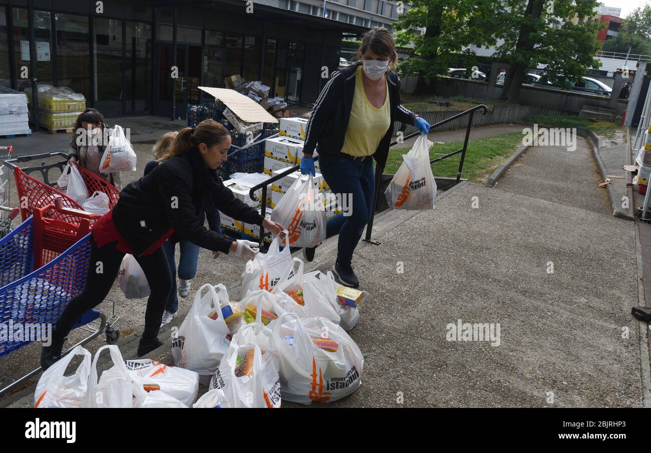April 29, 2020 - Clichy-sous-Bois, France: A food distribution takes place for the residents of Clichy-sous-Bois during the lockdown against the coronavirus outbreak. This northern suburb of Paris is located in Seine-Saint-Denis, one of the poorest in France, which has suffered one of the highest contamination and death rates from Covid-19. Volunteers from the Aclefeu collective delivered aid distribution for almost a thousand people on his occasion. Distribution de nourriture par le collectif Aclefeu pendant le confinement contre l'epidemie de covid-19. Les mesures contre le coronavirus ont a Stock Photo