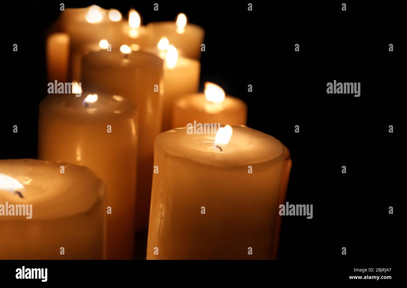 Many burning candles on dark background, closeup Stock Photo - Alamy
