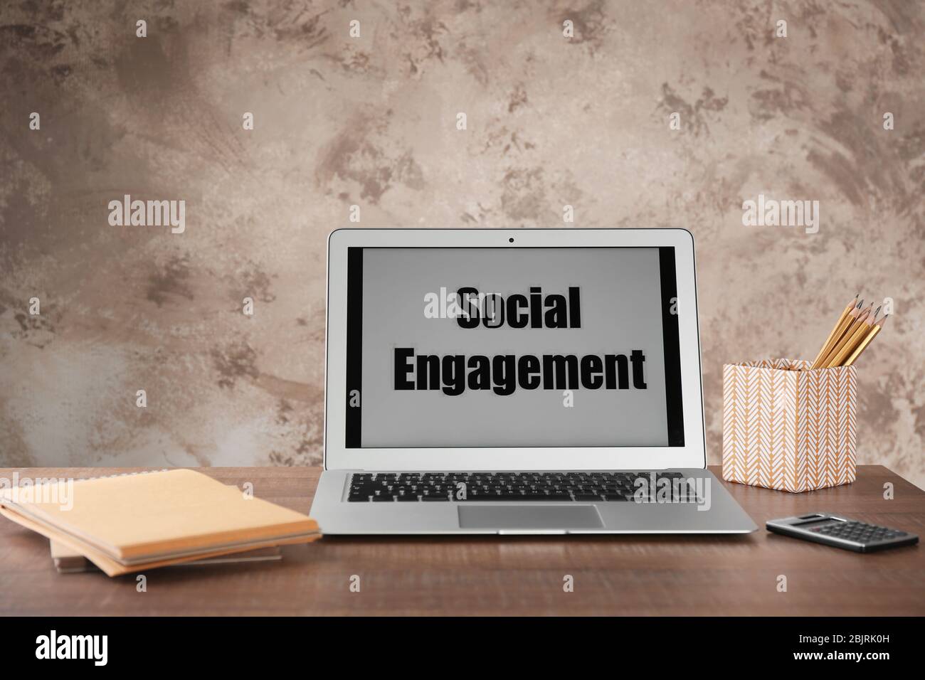 Laptop with text SOCIAL ENGAGEMENT on office table Stock Photo