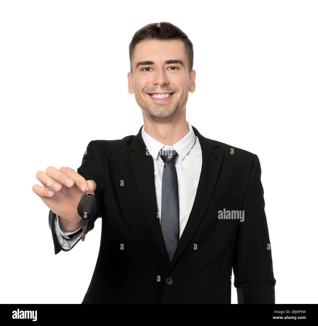 Attractive salesman holding car key on white background Stock Photo - Alamy