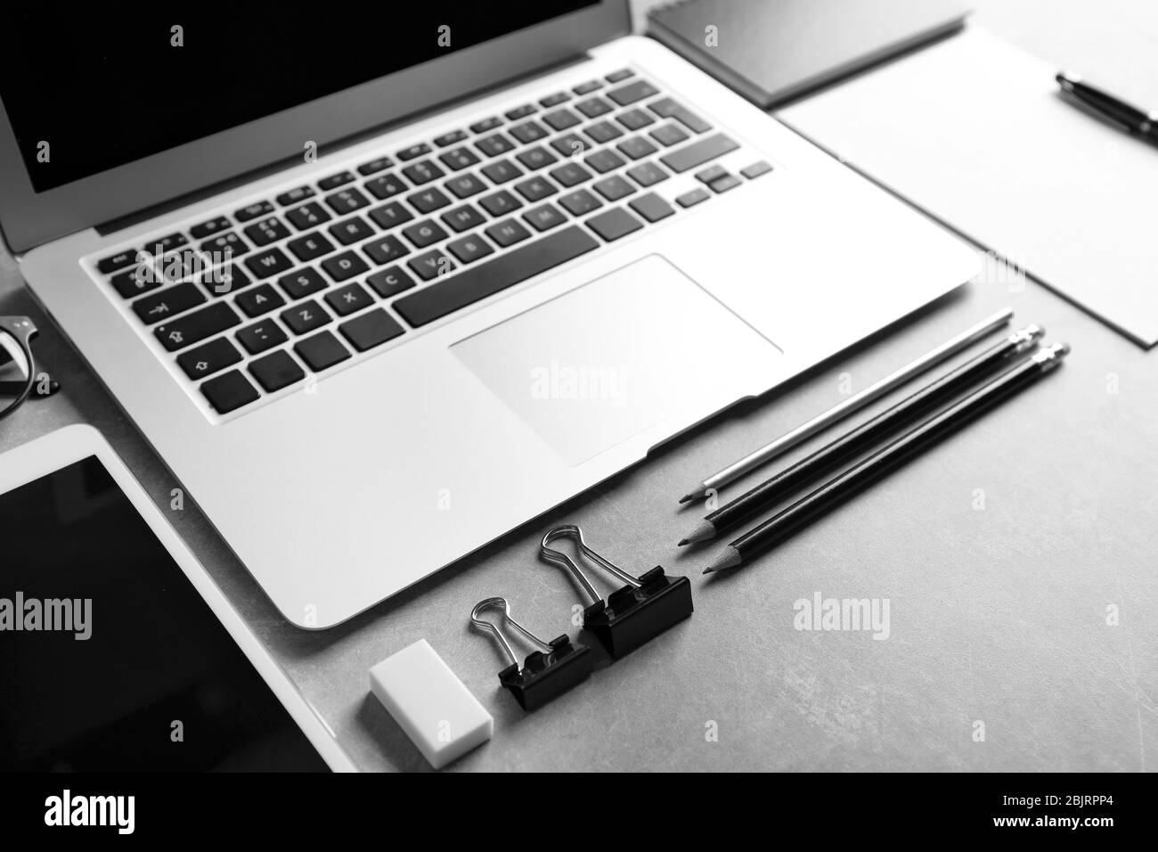 Modern laptop and stationery on grey background. Mockup for design Stock Photo