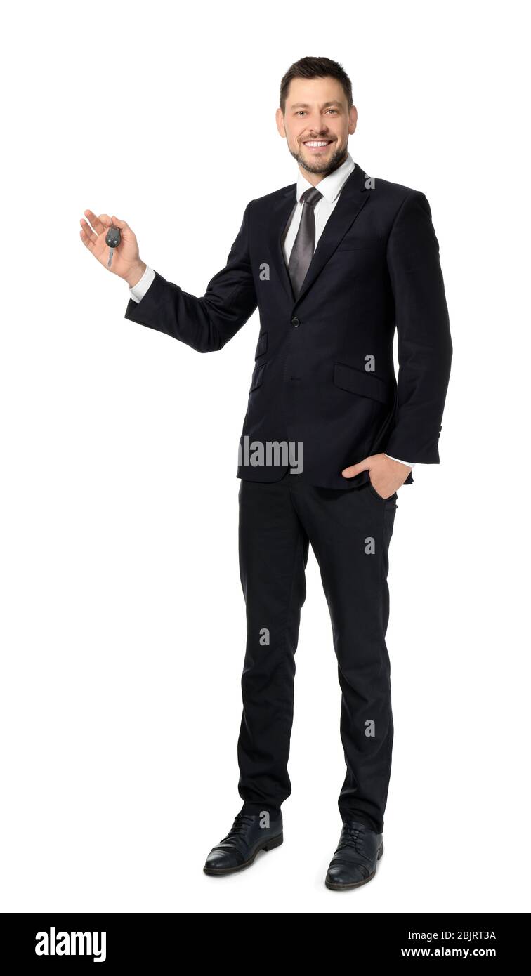 Attractive salesman holding car key on white background Stock Photo - Alamy