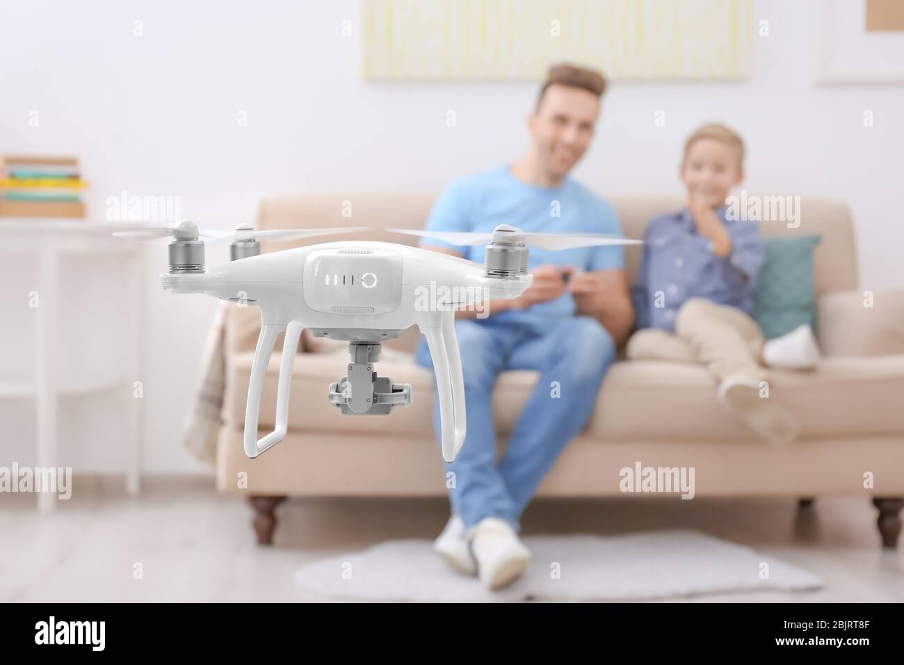 Cute boy and his father playing with drone at home Stock Photo - Alamy