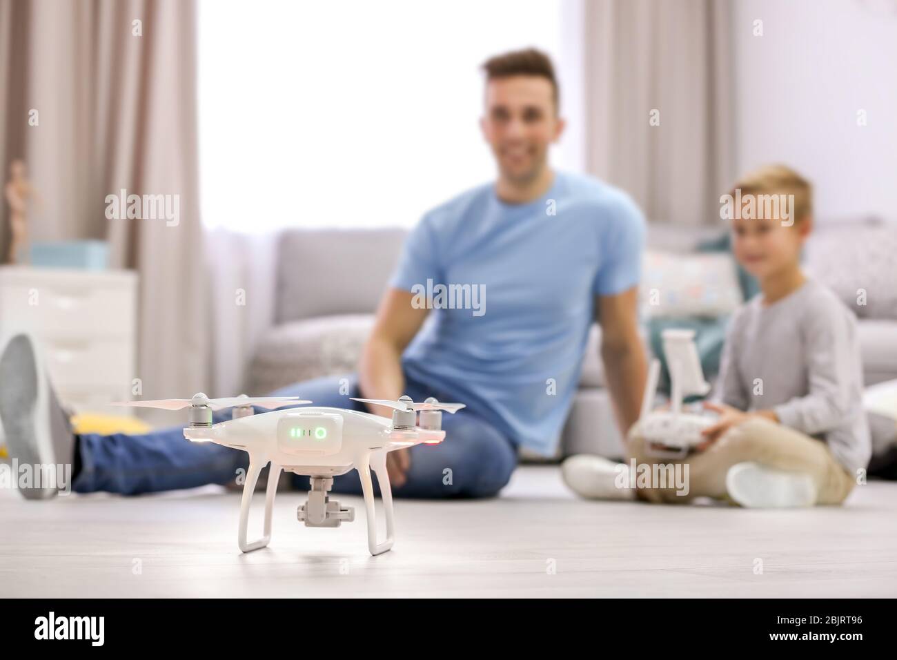 Cute boy and his father playing with drone at home Stock Photo - Alamy