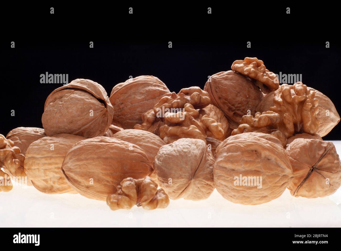open and closed chestnuts with back light on black background. Stock Photo