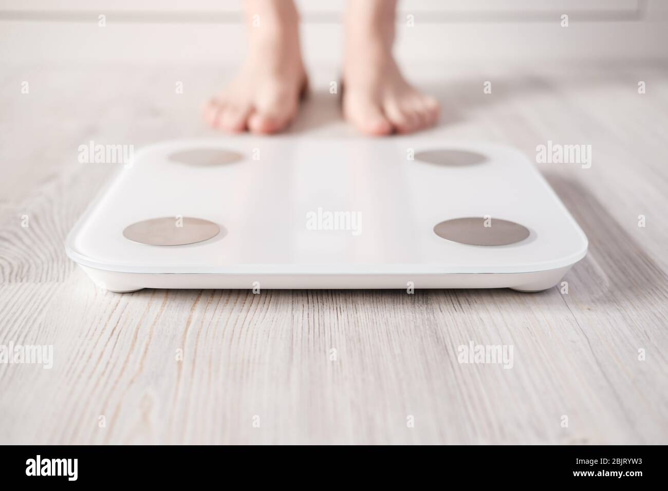 Smart scales with bioelectric impedance analysis, BIA, measuring body fat,  on the background of blurry female legs Stock Photo - Alamy