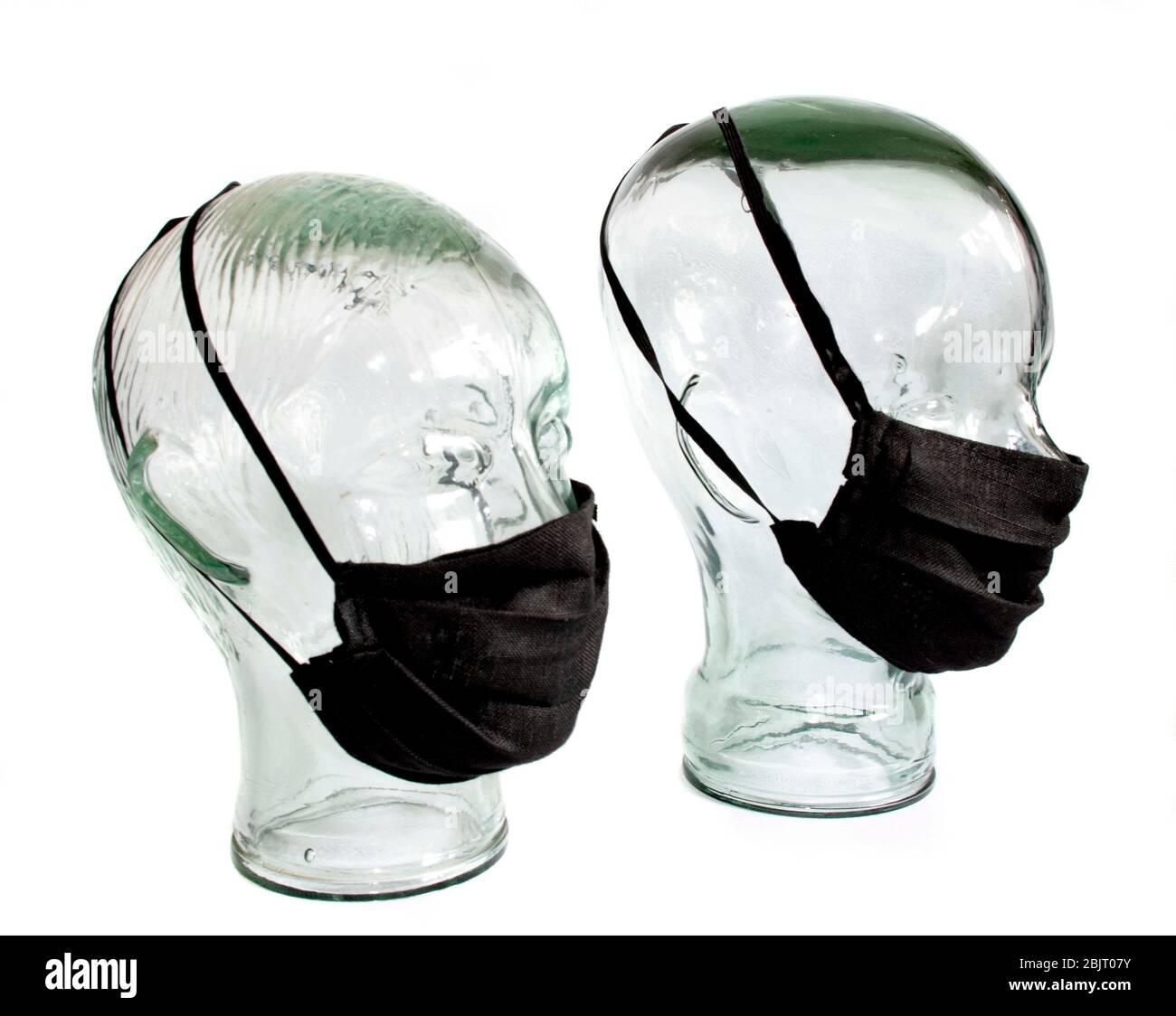 Protective face masks on a faceless glass head PPE Personal Protective equipment  white back ground Stock Photo