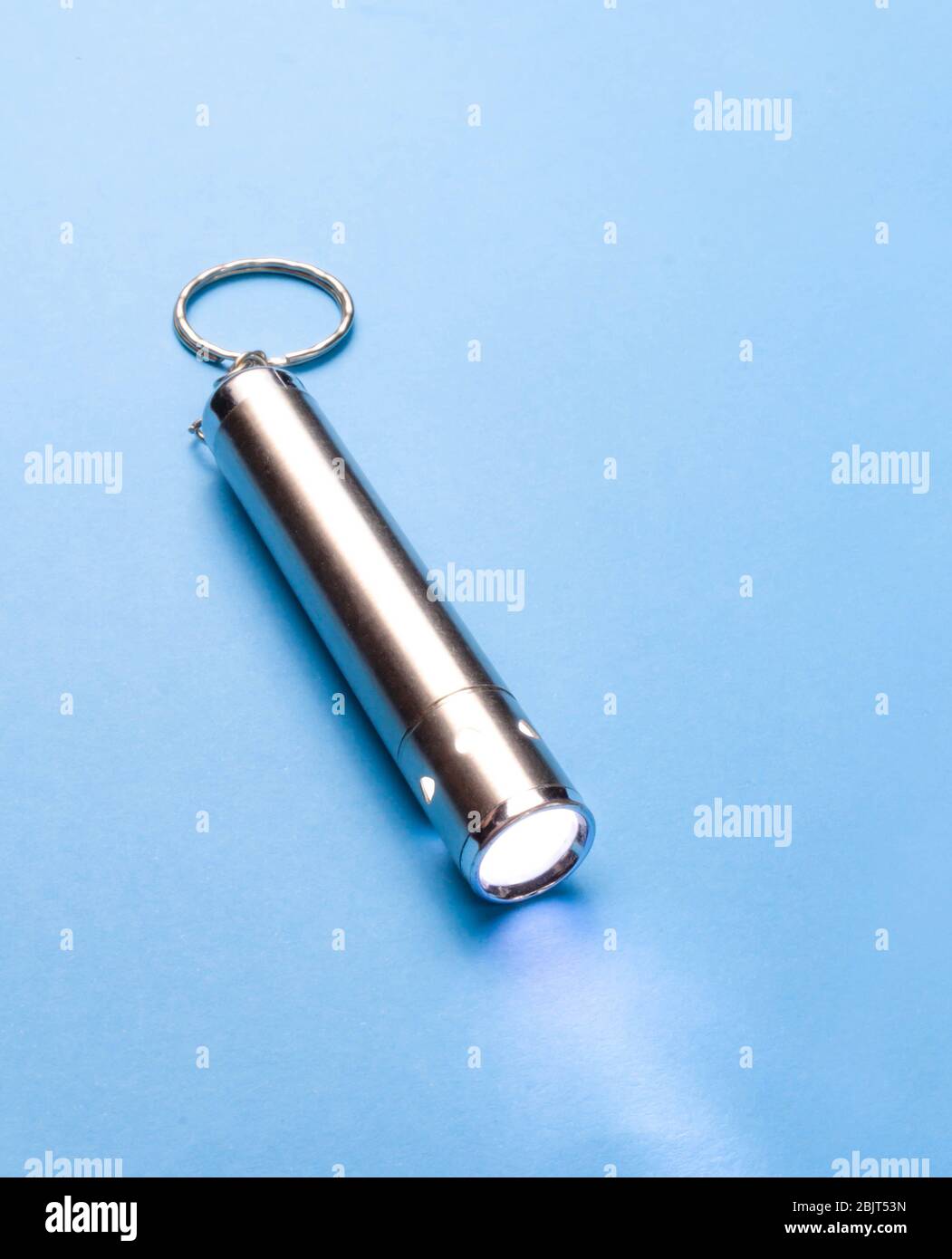 Small flashlight on a blue background Stock Photo