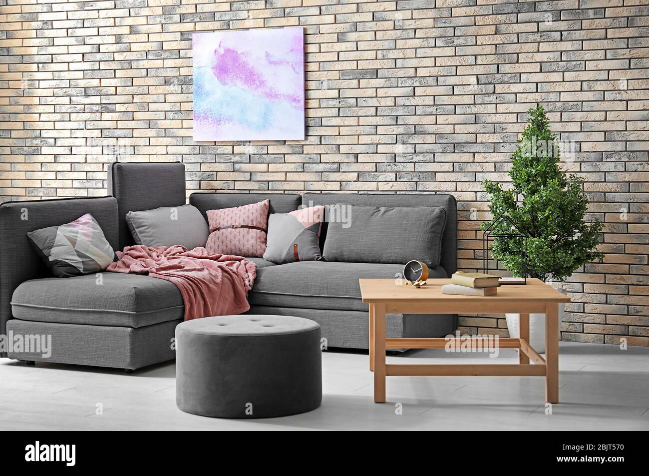 Modern living room interior with comfortable couch and grey ottoman ...