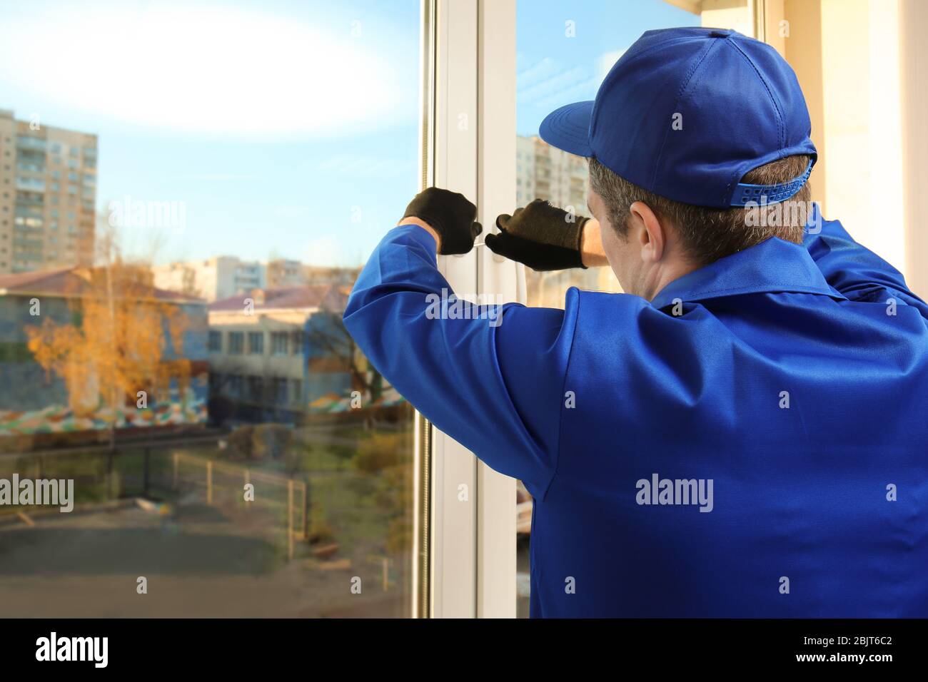 Construction worker repairing window in house Stock Photo - Alamy