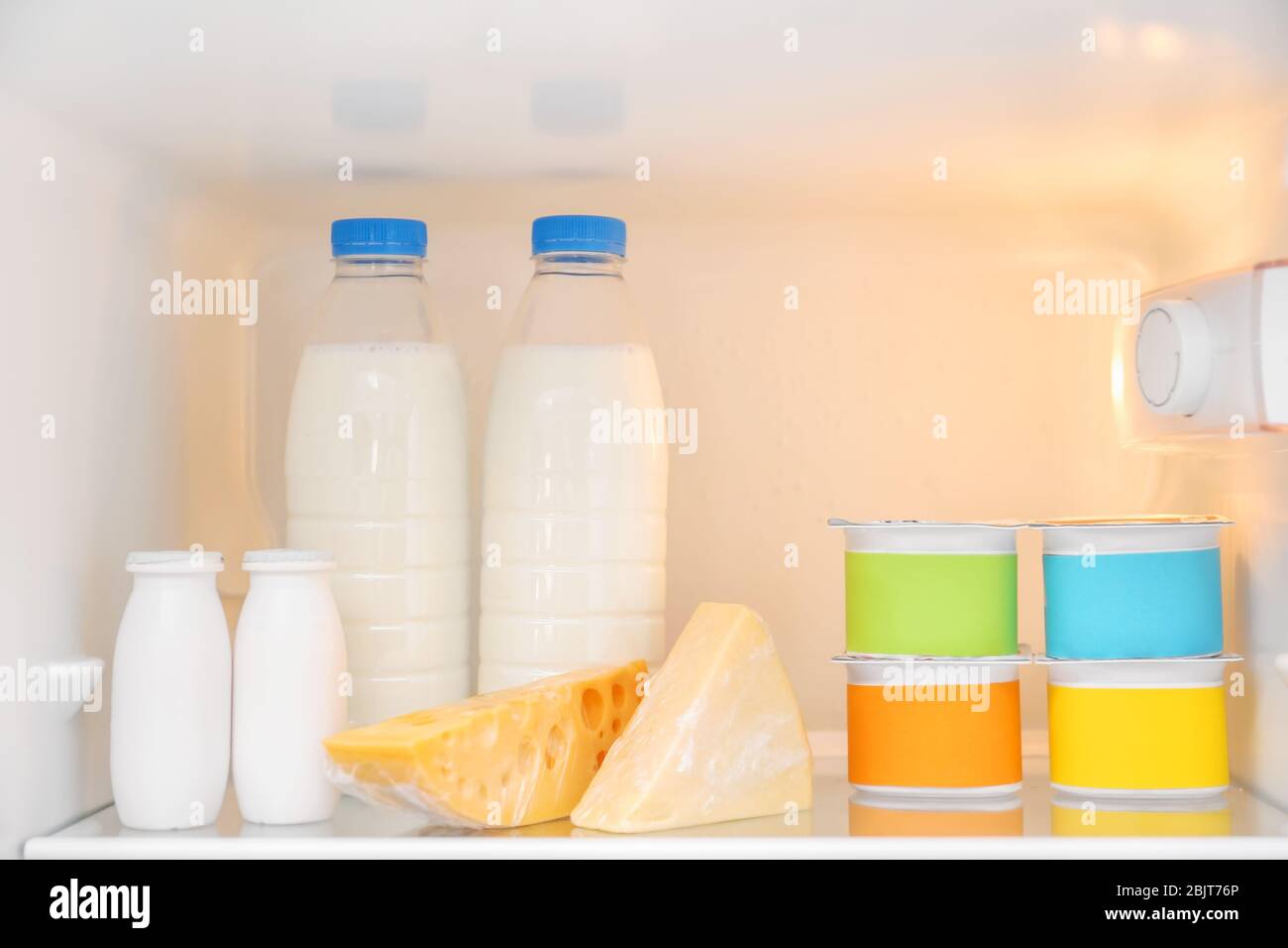 Dairy products on refrigerator shelf Stock Photo