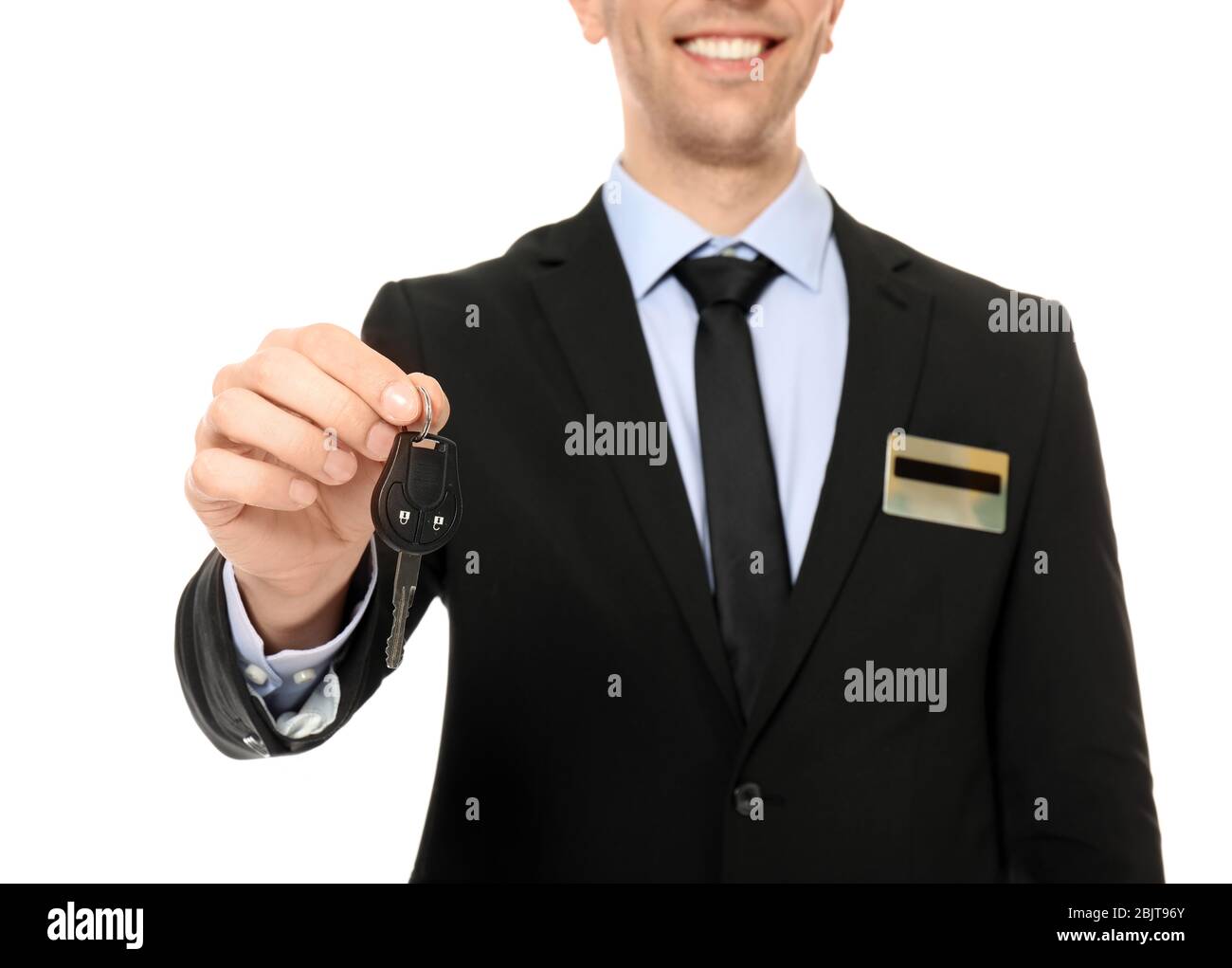 Young salesman holding car key on white background Stock Photo - Alamy