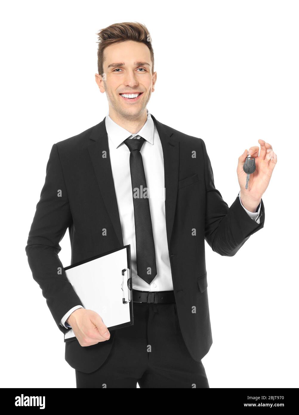 Young salesman holding car key on white background Stock Photo - Alamy