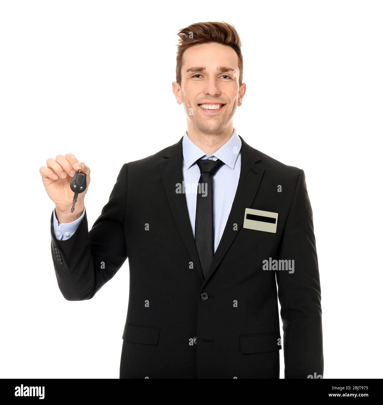 Young salesman holding car key on white background Stock Photo - Alamy