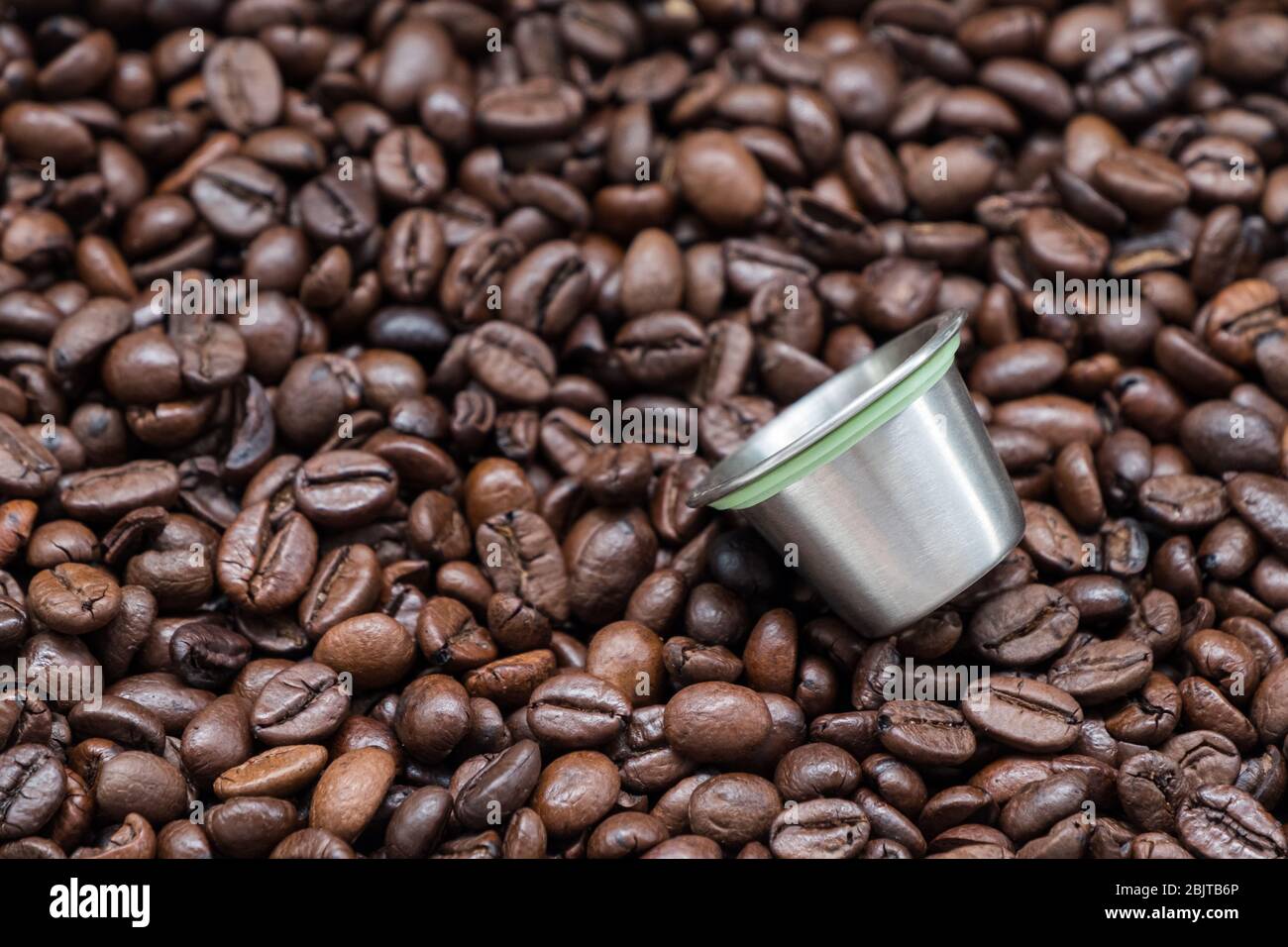 Reusable metal coffee capsule on the dark roasted coffee bean for use