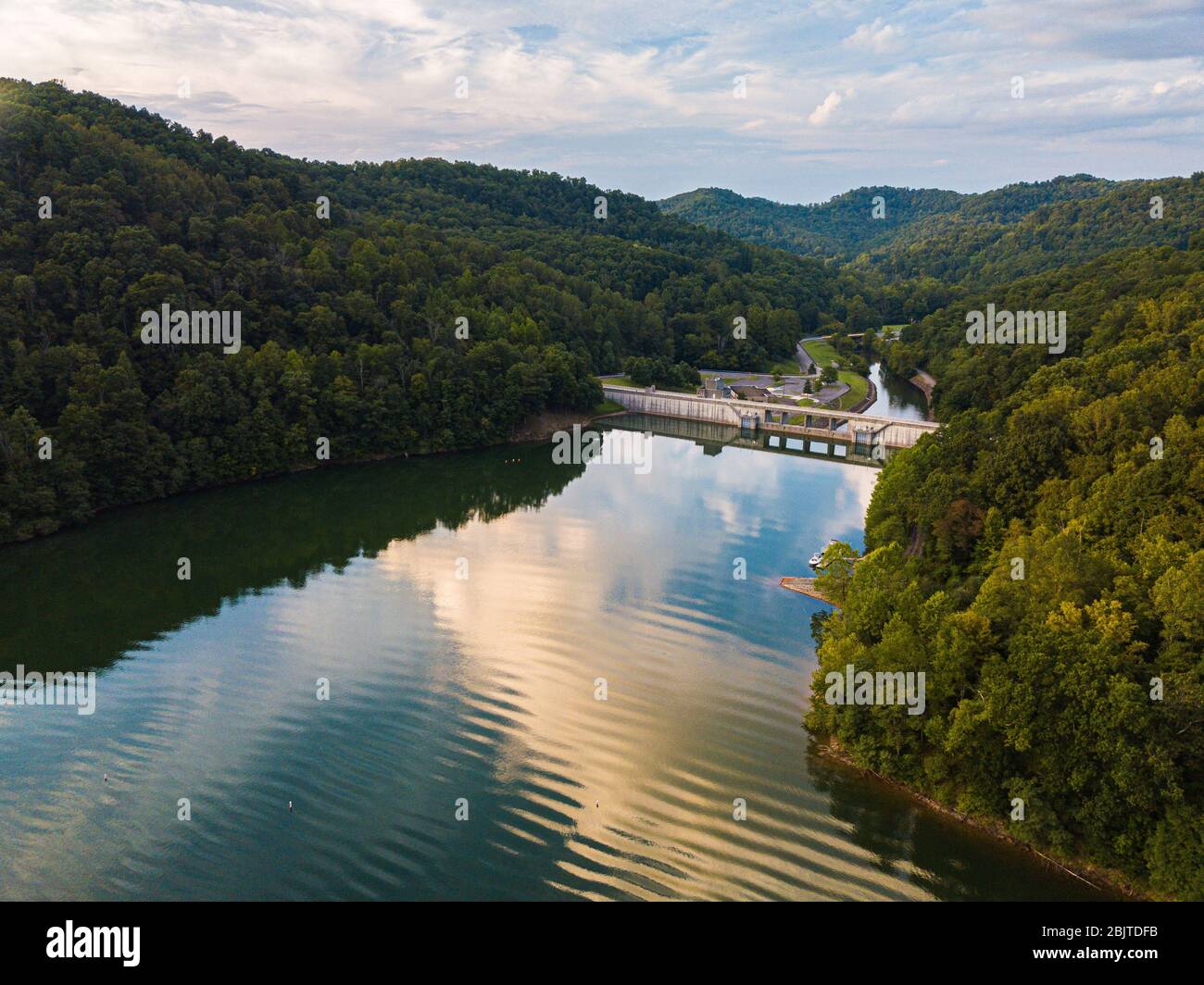 The rippled surface of Stonewall Jackson Lake in West Virginia reflects the deep blue sky and passing clouds as viewed from below the dam. Stock Photo