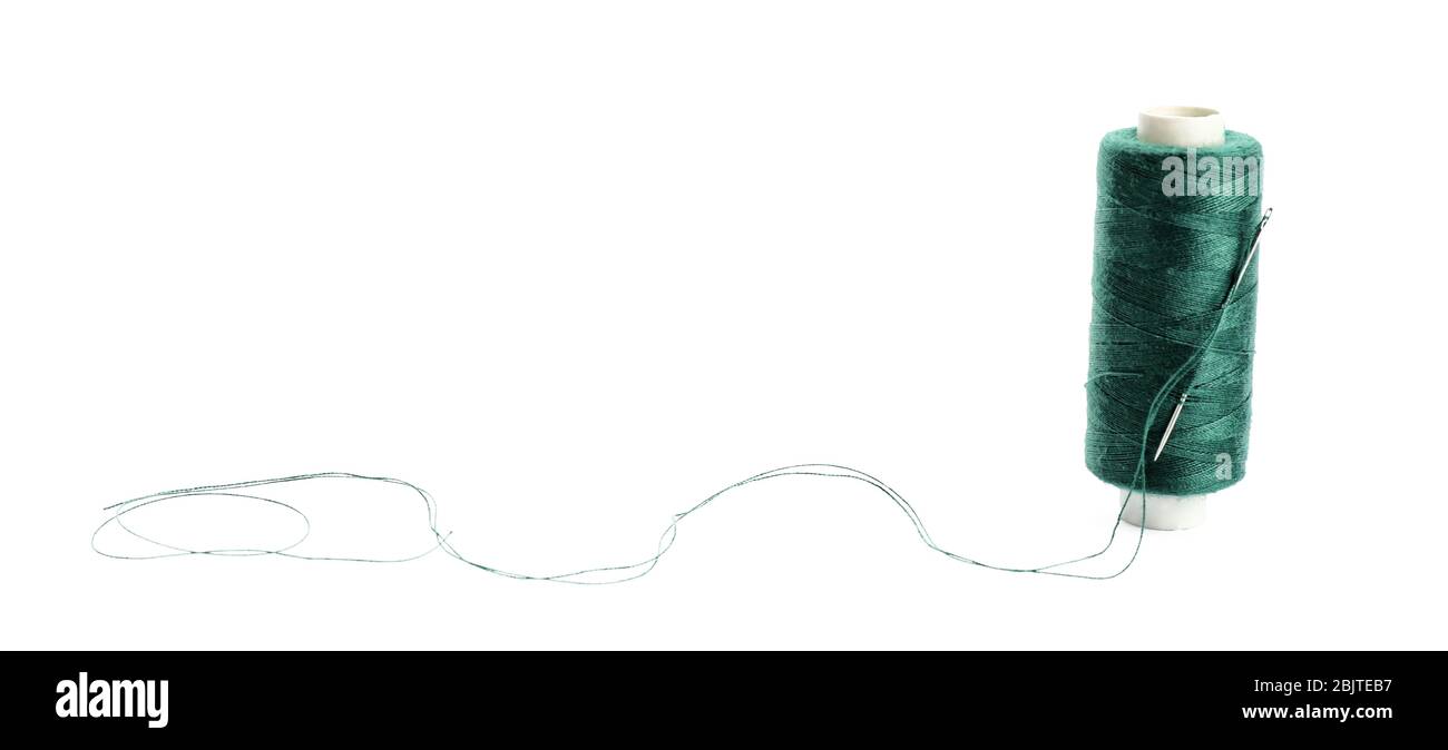 Spool of sewing thread with needle on white background Stock Photo - Alamy