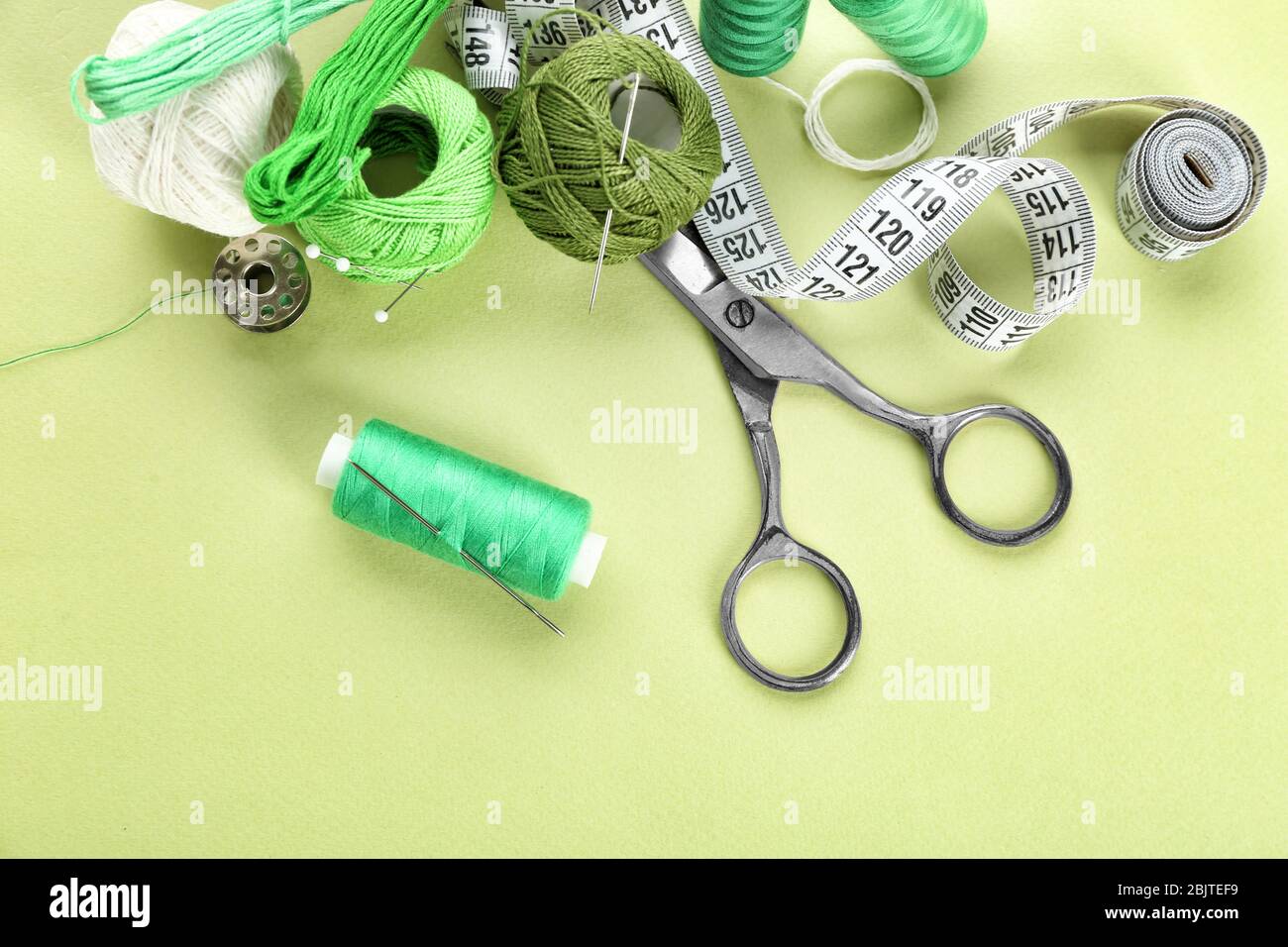 Sewing accessories and threads on color background Stock Photo - Alamy