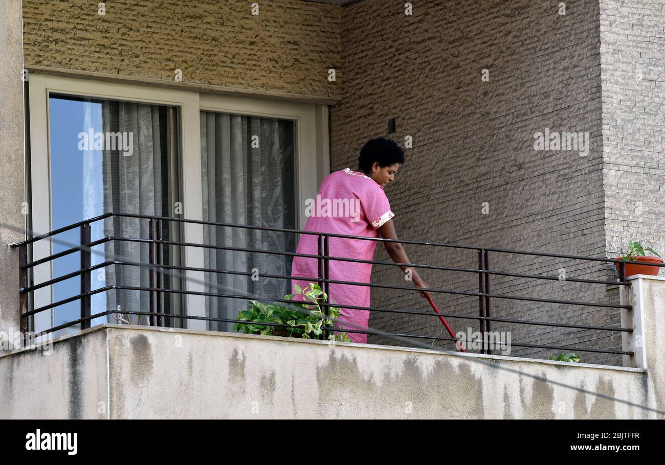 Migrant worker cleaning her employers’ apartment balcony, east Beirut, Lebanon. Stock Photo