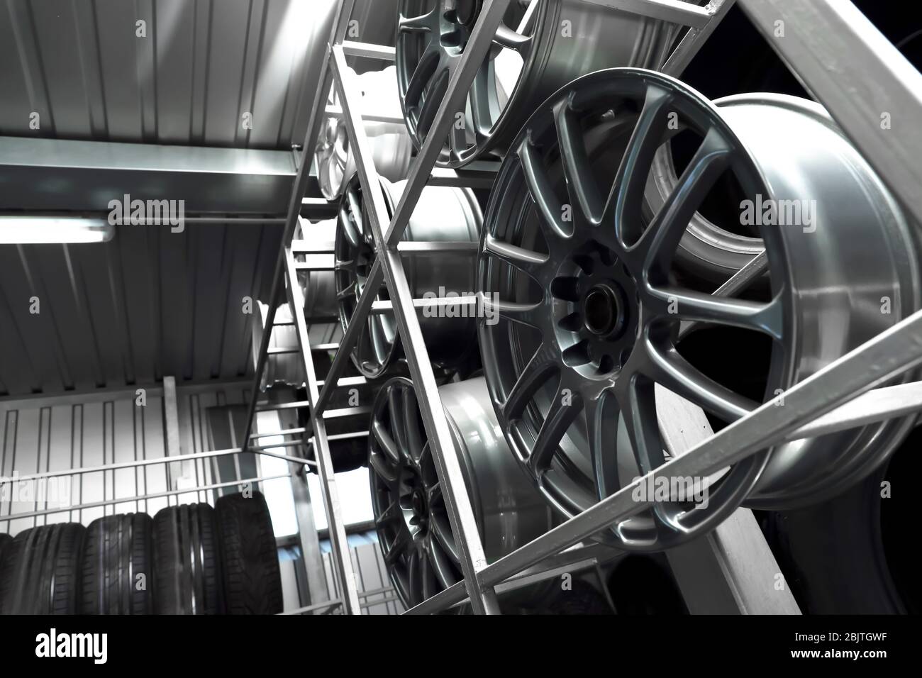 Rack with car wheels in automobile store Stock Photo - Alamy