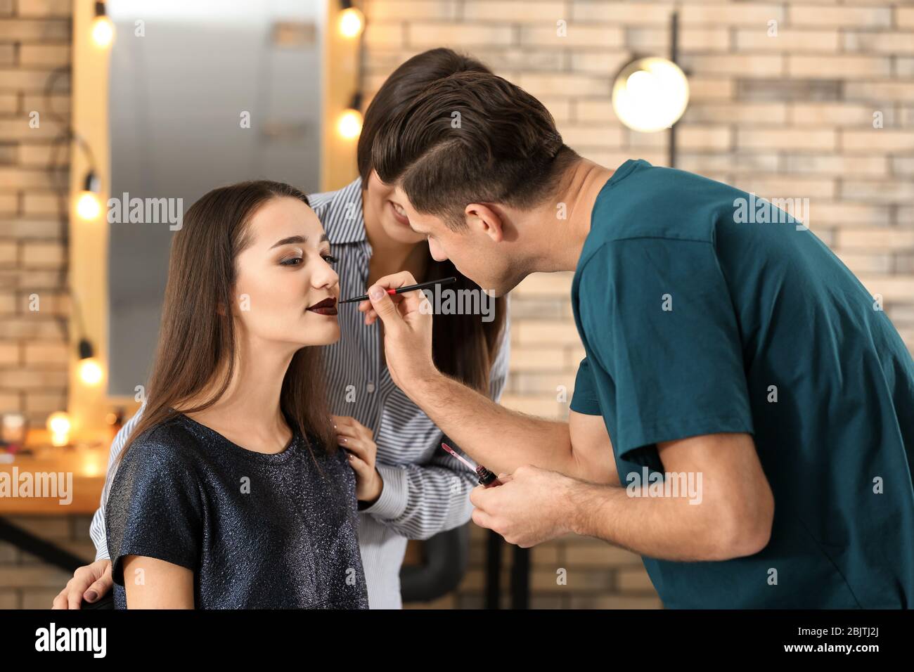 Professional makeup artist teaching trainee in salon. Apprenticeship