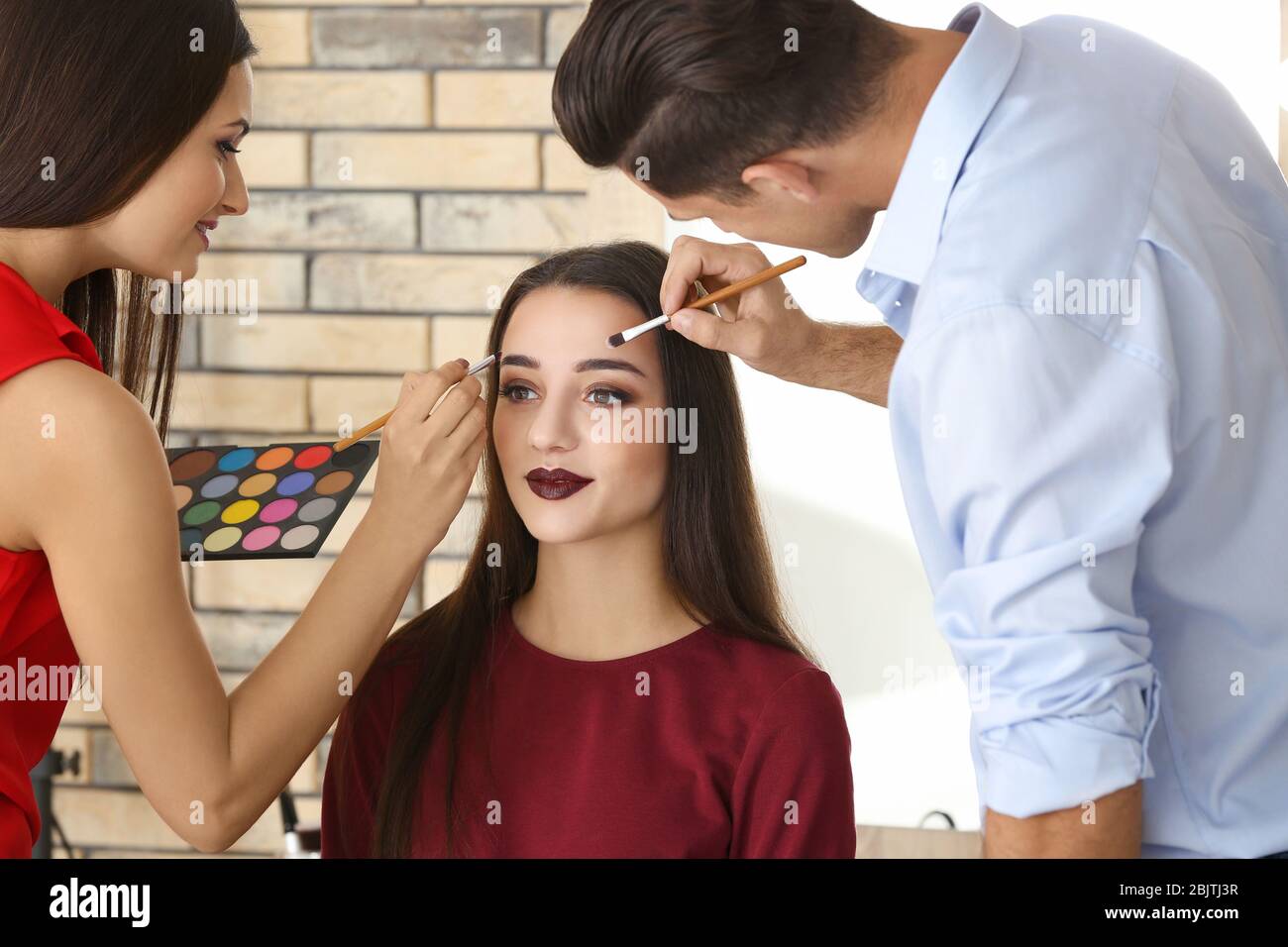 Professional makeup artist teaching trainee in salon. Apprenticeship