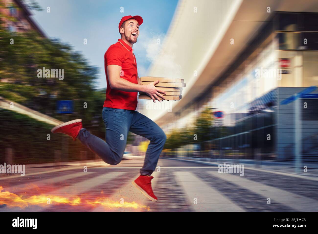Messenger in red uniform runs on foot really fast to deliver quickly hot pizzas just baked Stock Photo