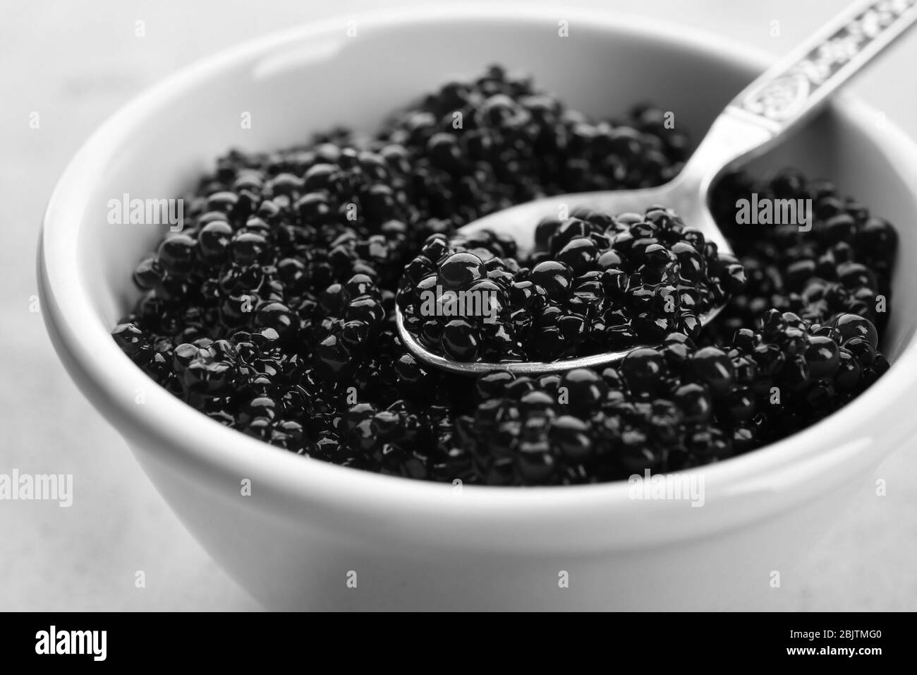 Ceramic bowl and spoon with black caviar, closeup Stock Photo - Alamy