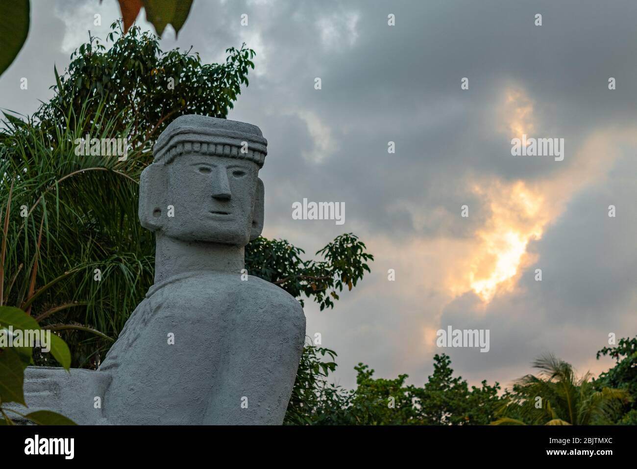 Chac Mool statue closeup detail on face against cloudy sky. Mayanand Aztec Chacmool symbolised slain warriors carrying offerings to the gods. Stock Photo