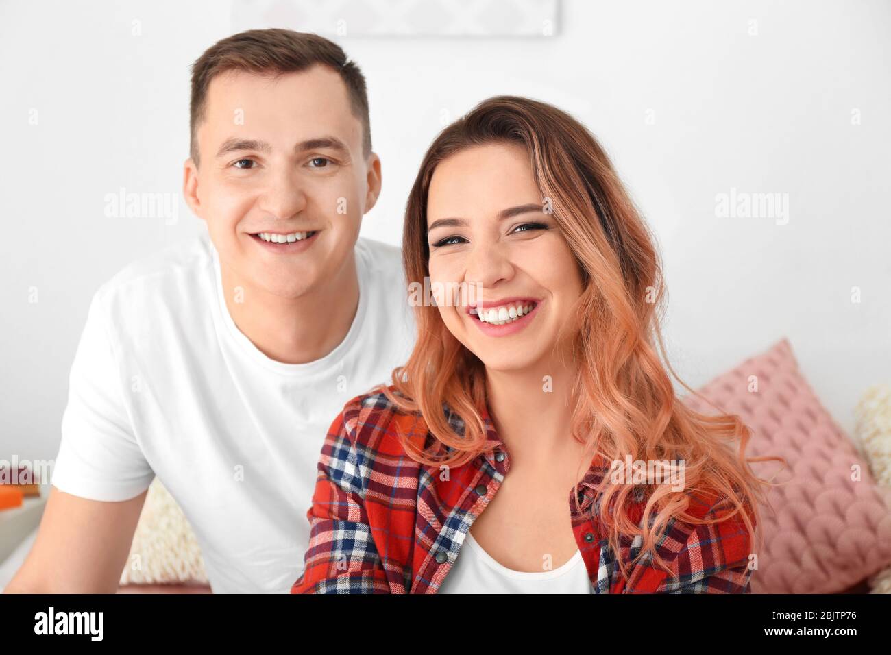 Portrait of cute young loving couple at home Stock Photo - Alamy