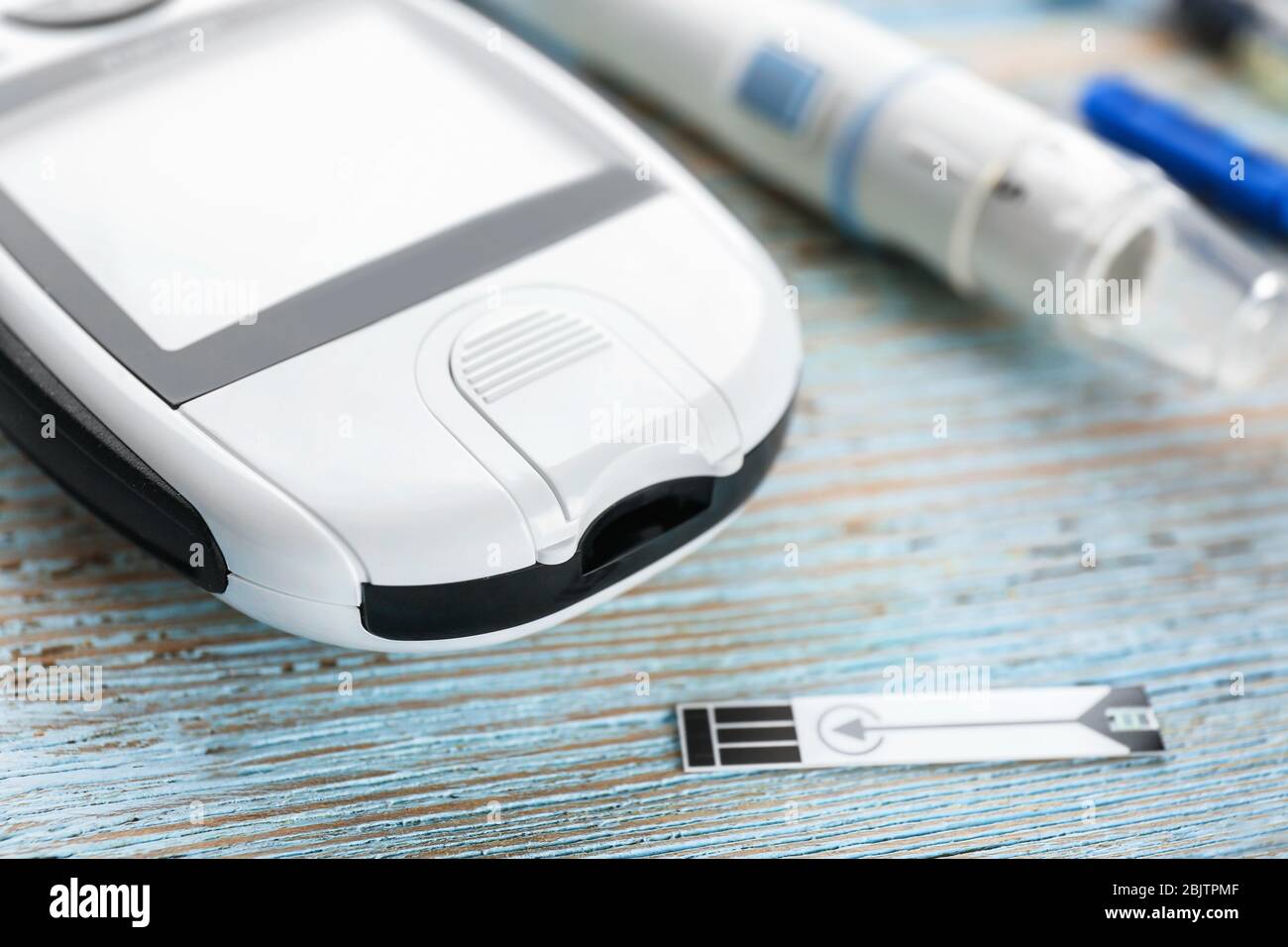 Digital glucometer on wooden background. Diabetes management Stock