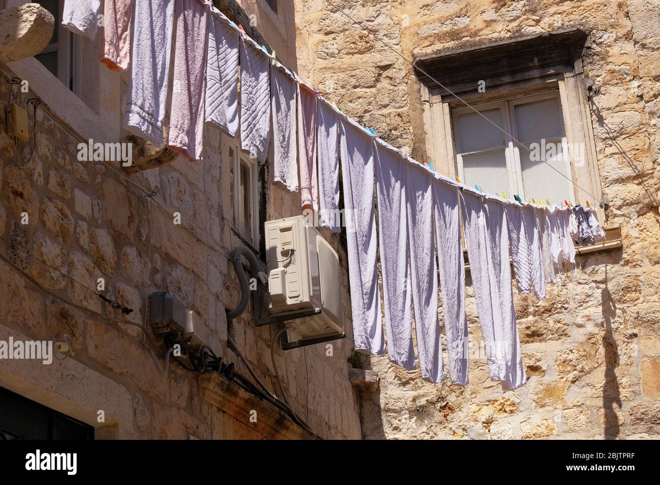 Fresh clean white clothes on a ropet. Traditional drying on washing line in outdoor. Stock Photo