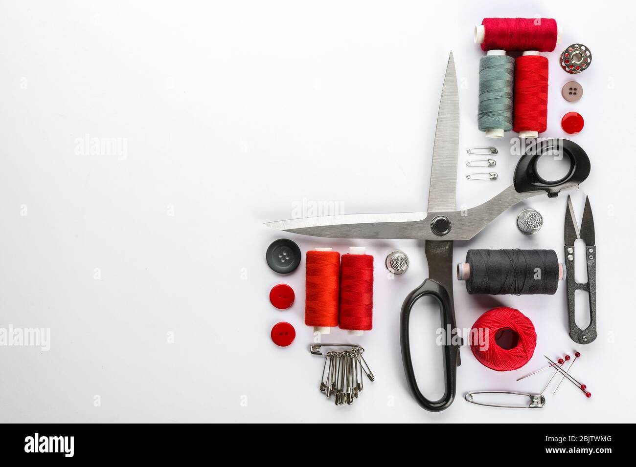 Composition with sewing threads, scissors and accessories on white background, top view Stock Photo