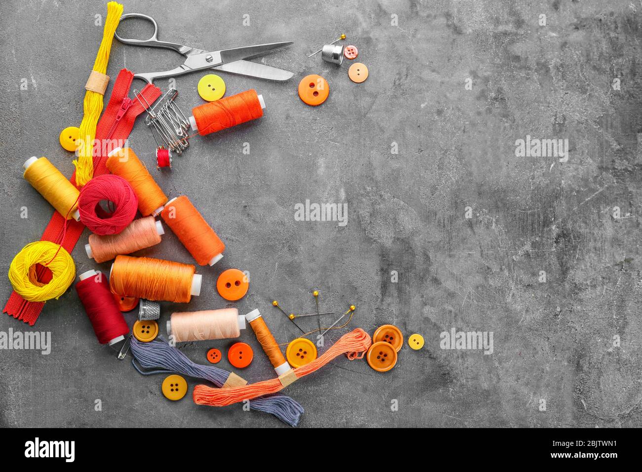 Composition with sewing threads and accessories on grunge background ...