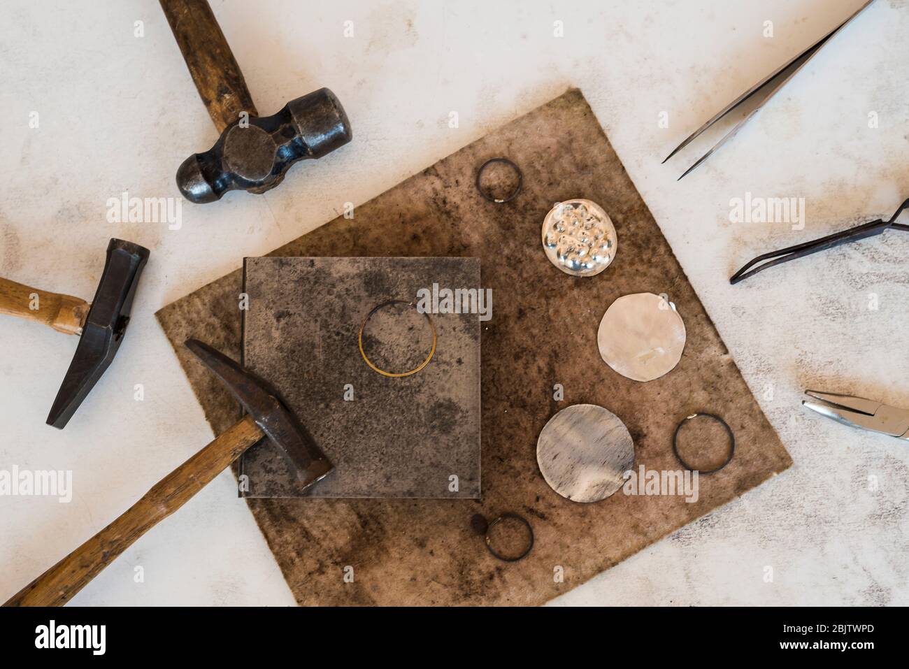 Tools of jewelery. Jewelry workplace on leather background. Hammers, anvil. Top view Stock Photo