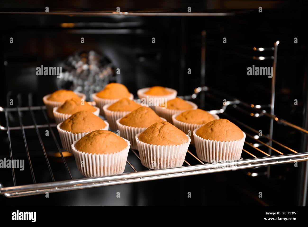 Tasty Cupcakes On Baking Rack In Oven Stock Photo - Alamy