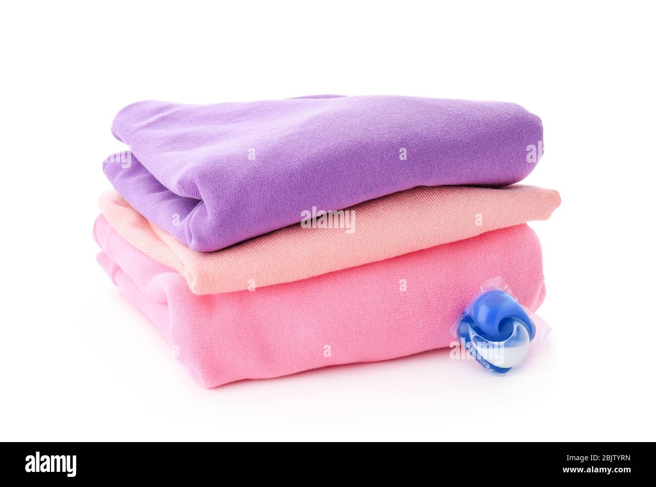 Stack of clothes and laundry pod on white background Stock Photo - Alamy