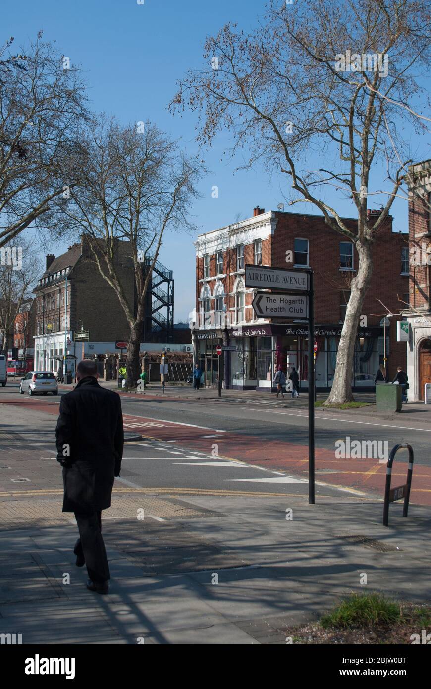 Man in Black Coat Walking Strolling Stroll Walk City on Chiswick High Road, London, W4 Stock Photo