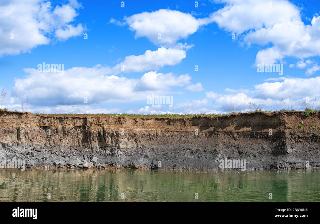 Background soil surface water flows through coastal erosion for a long time seen as a layer. Stock Photo
