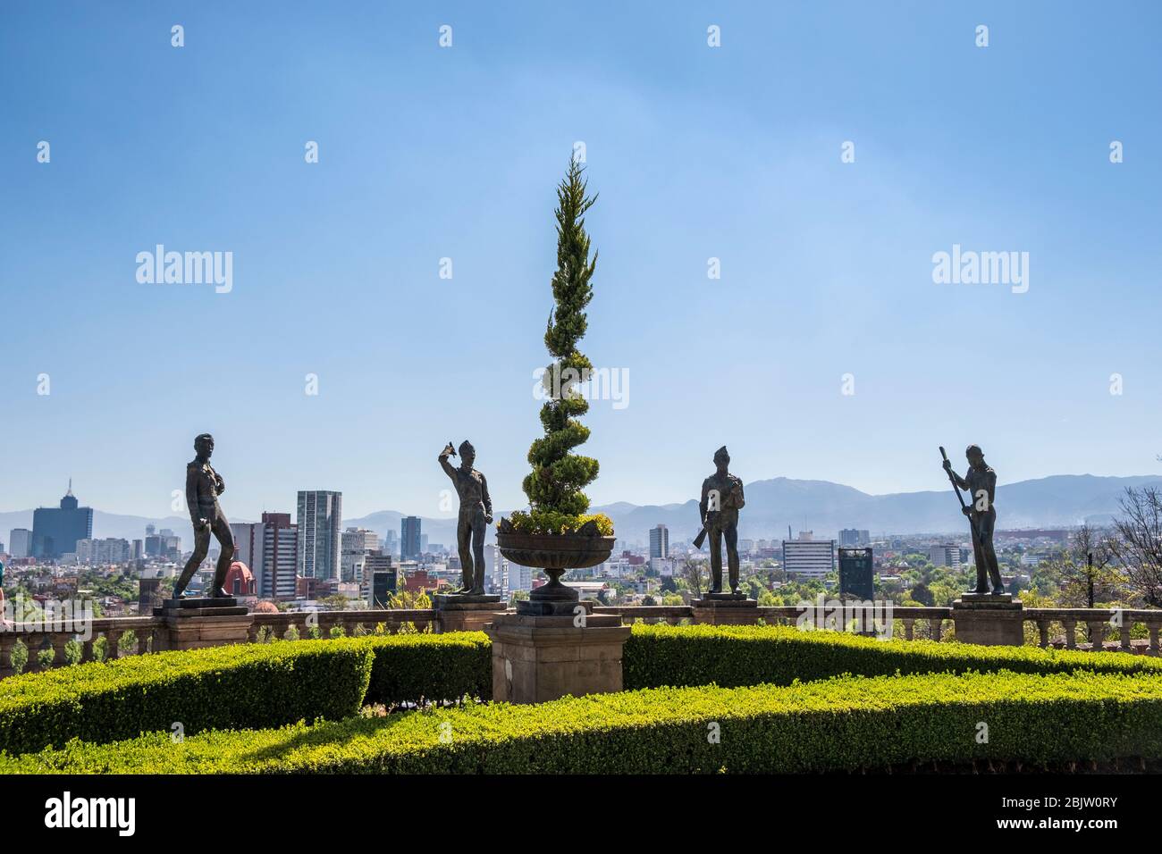 Skyline in daytime of Mexico City Statues of the Niños Héroes in foreground at Chapultepec Castle , Mexico City, Mexico Stock Photo