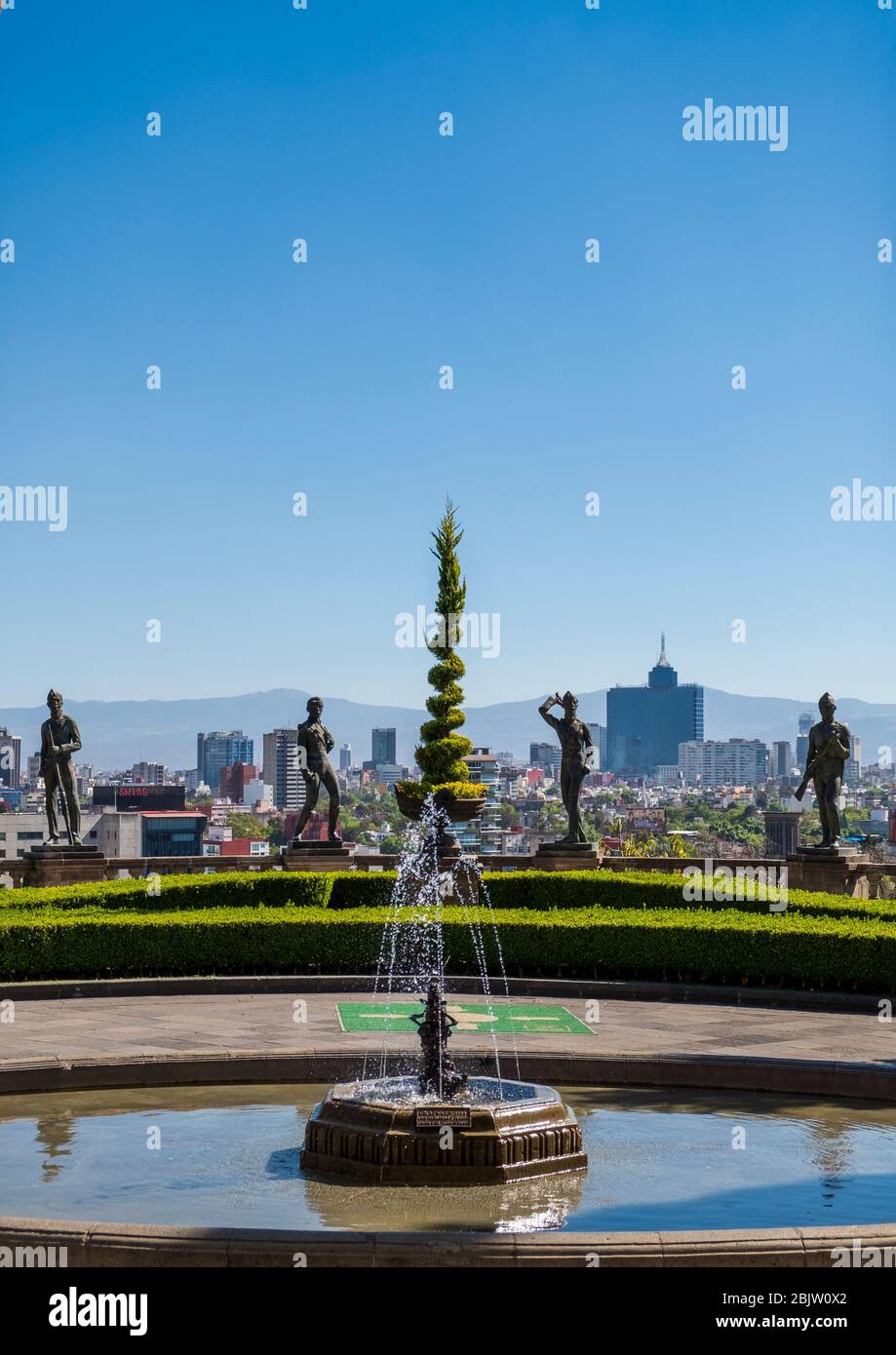 Skyline in daytime of Mexico City Statues of the Niños Héroes in foreground at Chapultepec Castle , Mexico City, Mexico Stock Photo