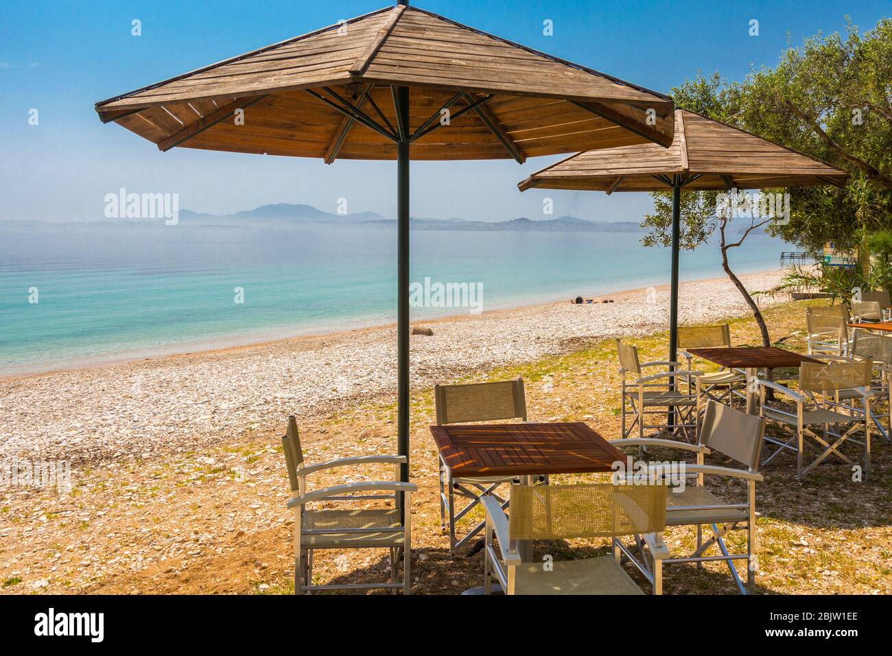 Sun umbrellas and seating at Barbati Beach, Corfu, Greece Stock Photo