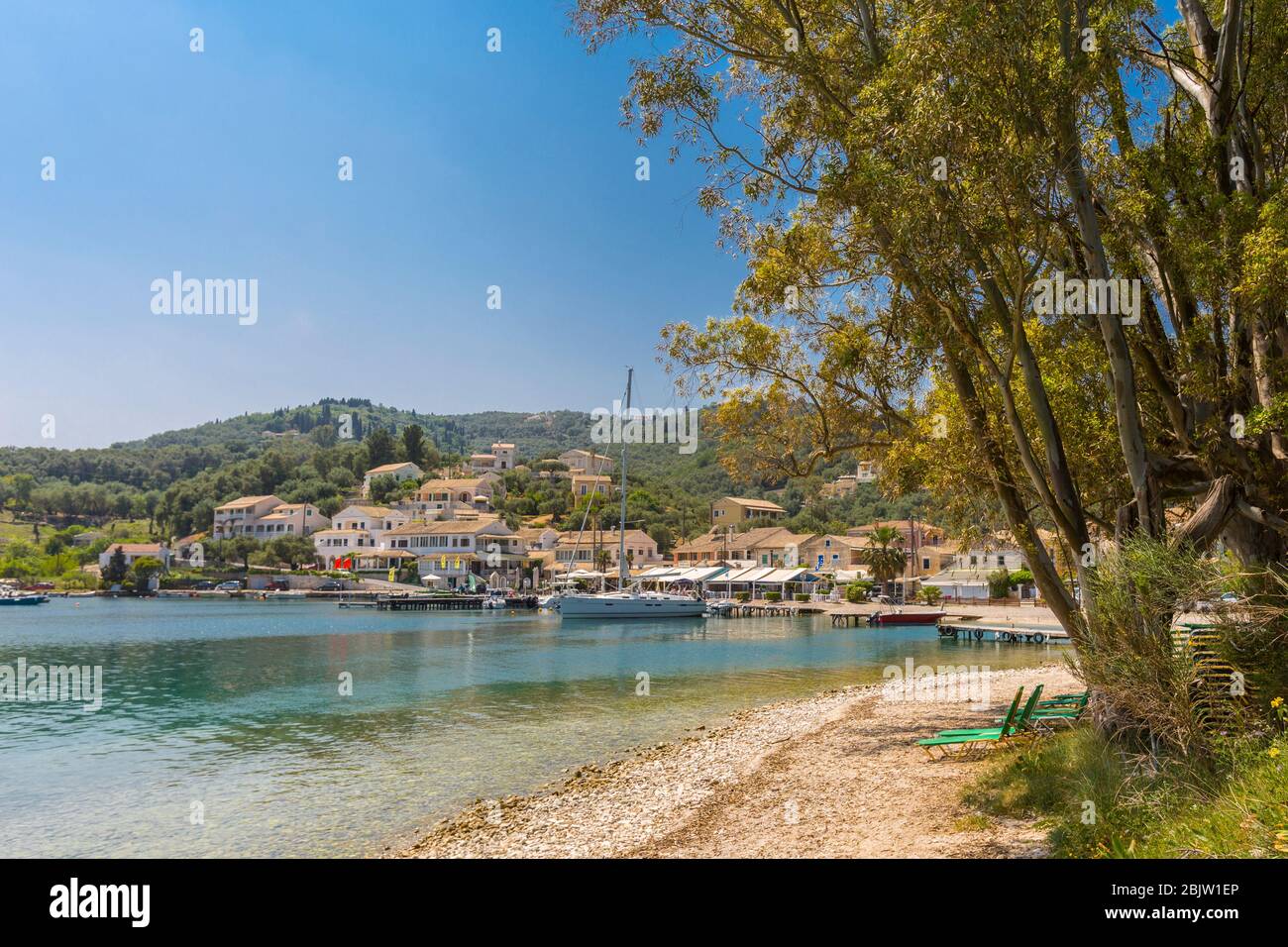 View across water towards Agios Stefanos fishing villas in Corfu, Greece Stock Photo