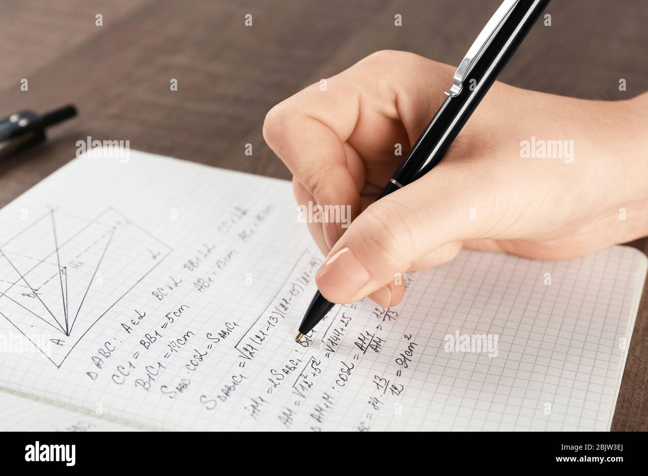 Woman doing homework in exercise book, closeup Stock Photo