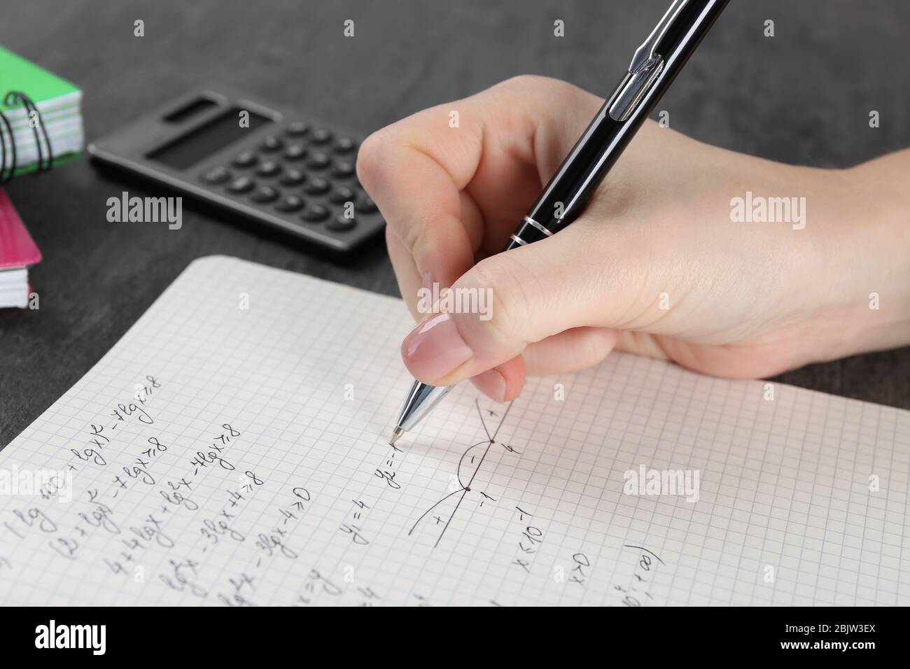 Woman doing homework in exercise book, closeup Stock Photo