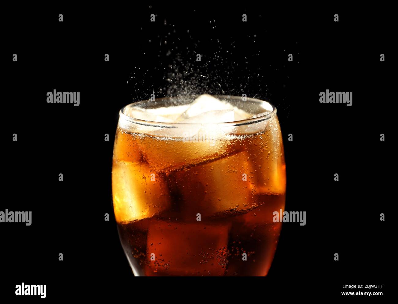 Glass of refreshing cola with ice on black background, closeup Stock ...