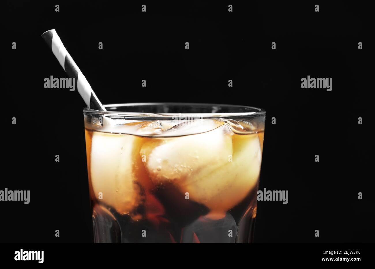 Glass of refreshing cola with ice on black background, closeup Stock ...